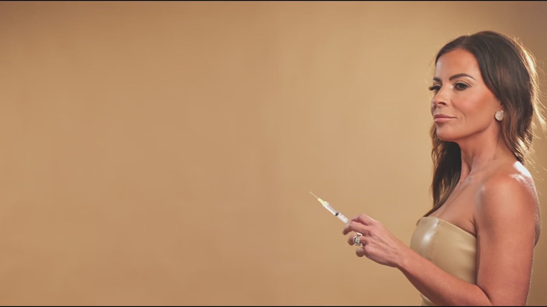 Load video: Video montage of woman holding a syringe, a bbl treatment, a Botox injection and a facial