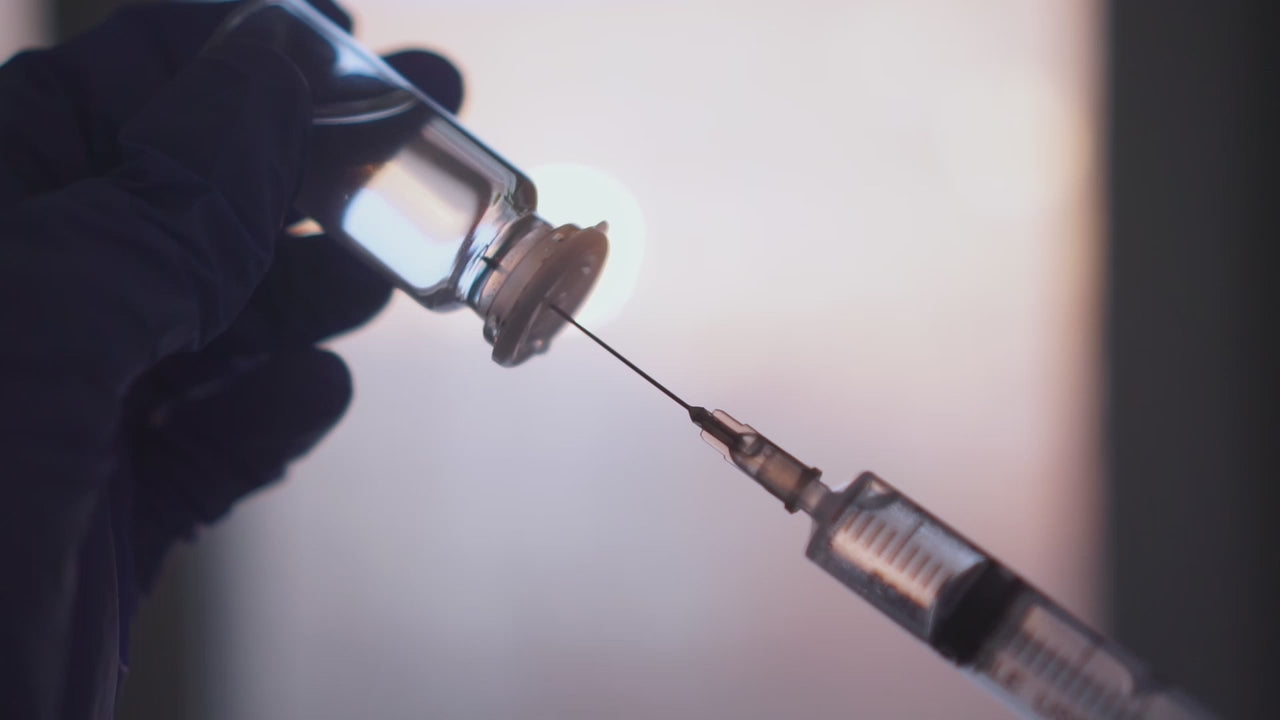 Load video: Syringe drawing up a vitamin based solution for injection.